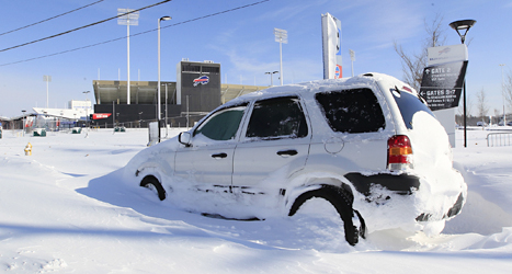 En bil har fastnat i snön i delstaten New York i USA. Foto: Harry Scull/TT.